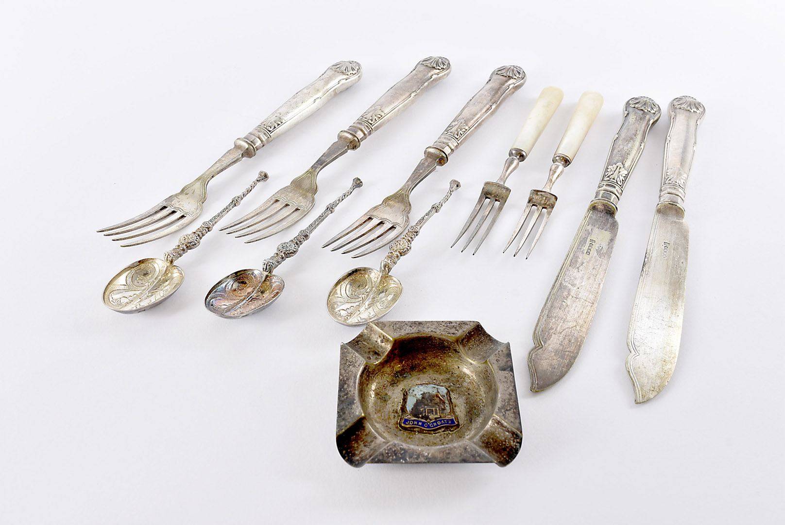 A collection of silver and plated flatware, including six silver teaspoons, a silver fork, feeding