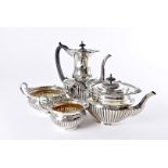 An Edwardian four piece silver tea set by Walker & Hall, fluted lower sections and having ornate