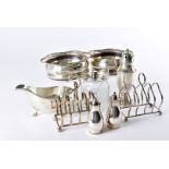 A collection of silver plated items, including a set of three wine bottle coasters, sauce boat,