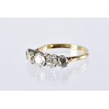 An Edwardian period five stone diamond engagement ring, the graduating old cuts in white metal