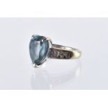 A modern 18ct white gold aqua marine and diamond dress ring, the tear drop shaped blue stone in
