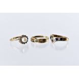 Three modern 9ct gold and gem set rings, including a wishbone shaped sapphire and diamond example, a