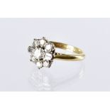 An Art Deco diamond cluster ring, the flower head tablet centred with a brilliant cut flanked by a