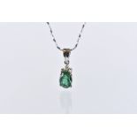 A modern silver and emerald pendant and earrings suite, with oval green stones heightened by small