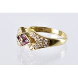 A modern 18ct gold ruby and diamond ring, diamond shaped tablet set with four red stones and a