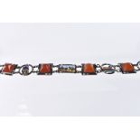A vintage Egyptian silver and enamel bracelet, four square panels with orange glass and other panels