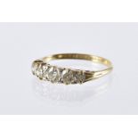 An Edwardian period or earlier five stone diamond ring, graduating brilliant cuts in scroll sided