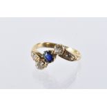 An Art Deco period 18ct gold diamond and sapphire ring, the crossover style tablet with central blue