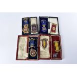 Four vintage Masonic jewels, two silver and two gilt metal, along with three further jewel ribbon