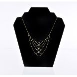 A pretty continental gold fringe necklace, small bead chain with five swags and set with four blue