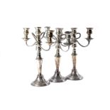 A harlequin set of four Sheffield plated two branch candelabra