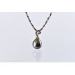 A modern 18ct white gold and black pearl pendant, heightened with diamonds to the scroll bale,