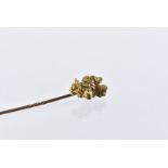 An Edwardian period gold nugget stick pin, the piece of gold ore attached by wire to a gold pin, 7.