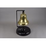 A George VI brass ships bell, having a George VI cipher to top of the bell, on stand