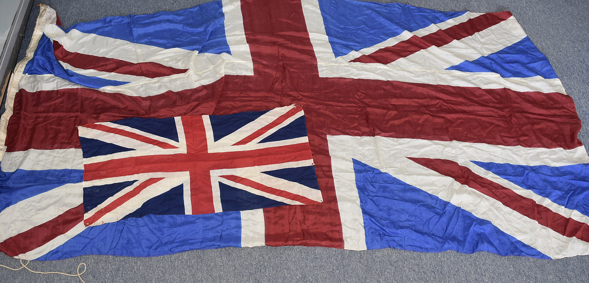 A large silk Union flag, approx 260cm by 130cm, together with an early nylon smaller example, approx
