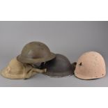 Three WWII Brodie helmets, in green, black and khaki, together with a painted liner of an M1