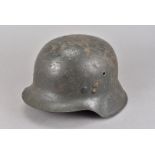 A WWII German M35 helmet, having fusilier style badge to one side, grey painted with partial white