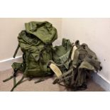 A 1965 military back pack with metal frame, together with two modern military back packs, full of