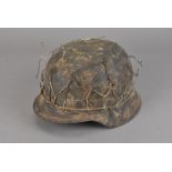A WWII Third Reich helmet, covered in wire, was found but a relative if the seller in Nazi Germany