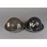 A WWII Warden's brodie helmet, marked with W's to front and rear, with a partial crest above one