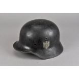 A Third Reich single decal helmet, black painted with eagle and swastika painted shield to one side,