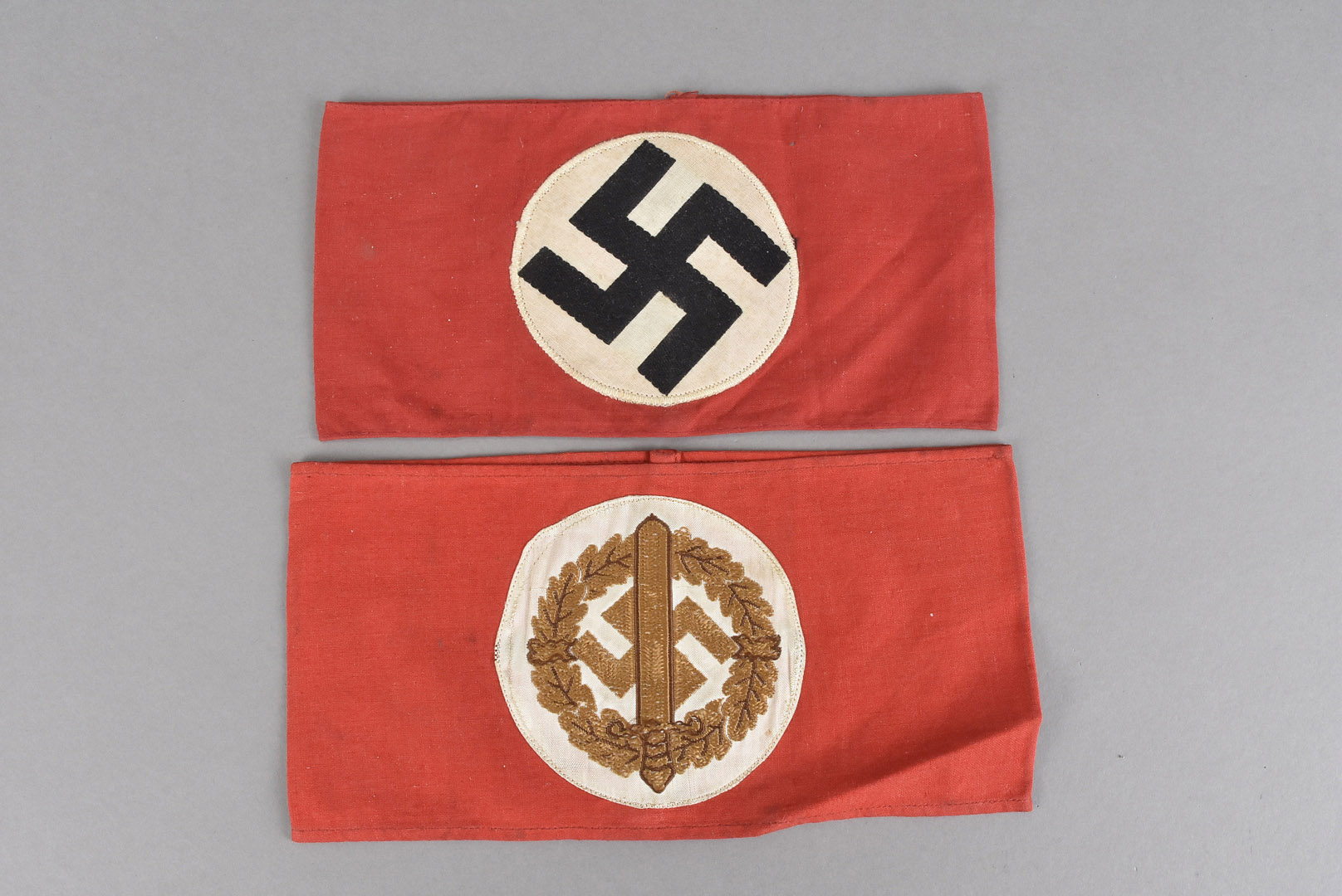 A WWII Third Reich armband, with applied swastika, together with a Third Reich SA Wehrmannschaft