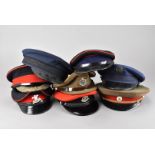 A collection of eight British and overseas peak caps, including two Military Police, one in green,