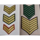 Two folders containing a collection of military rank chevrons, comprising Lance Corporal,