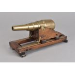 A small hand built mahogany and brass signalling cannon, the heavy brass cannon rests on mahogany
