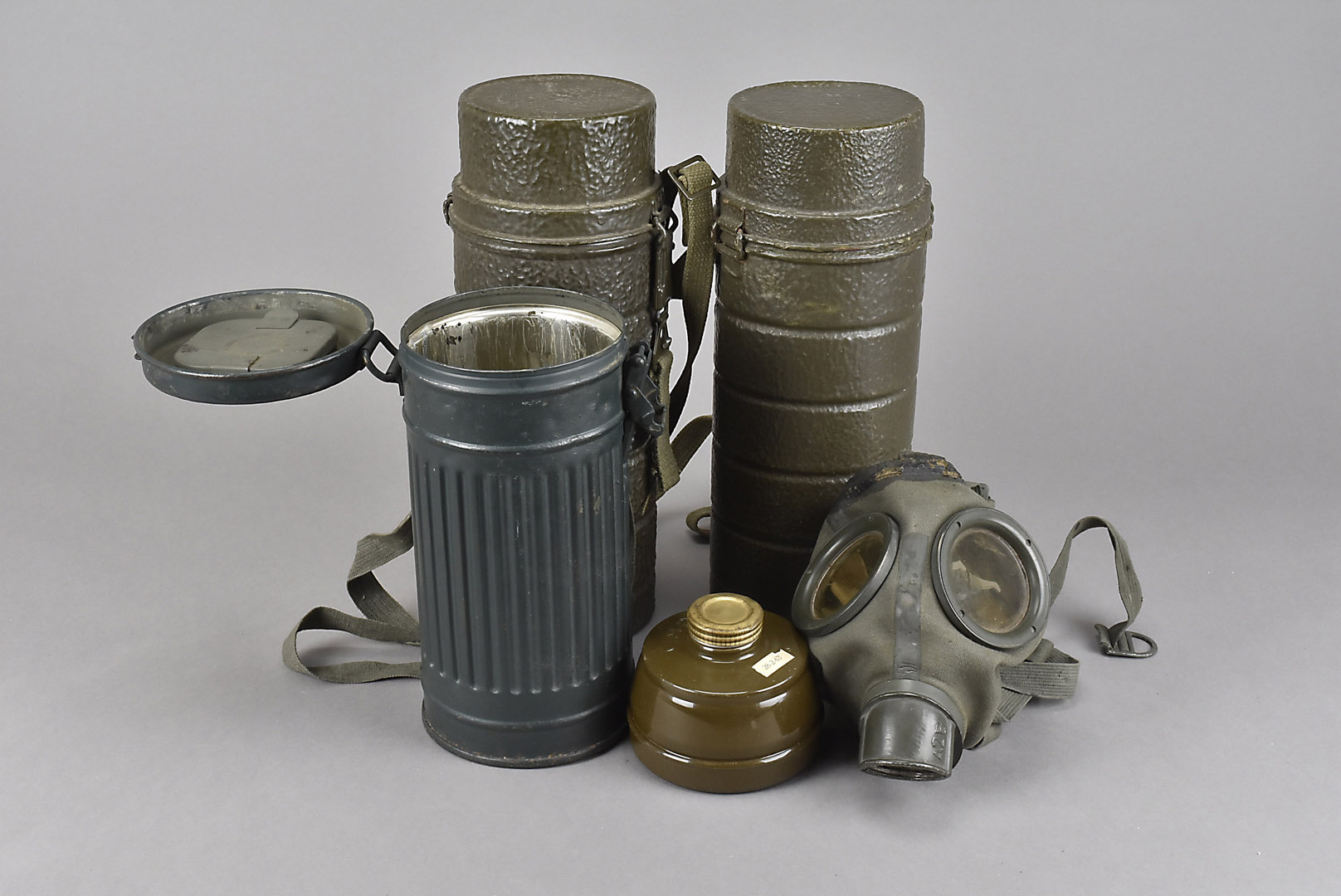 Three gas mask canisters, one containing a gas mask, the other two are just canisters (4)