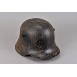 A WWI German M16 helmet, marked ET64 to inside, black painted, with liner