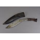 A Kukri knife, with engraved blade, in leather sheath, two smaller blades not present, blade