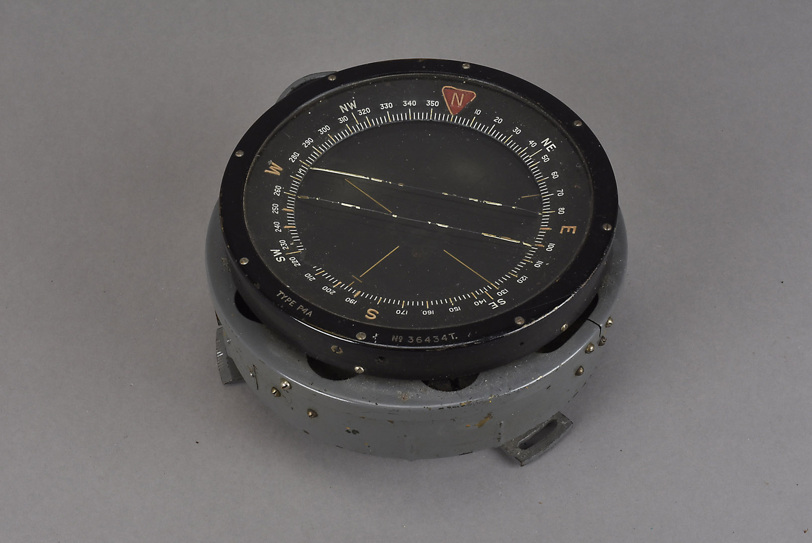 A WWII P4A planes gimbal compass, together with a planes steering wheel, complete with missile and