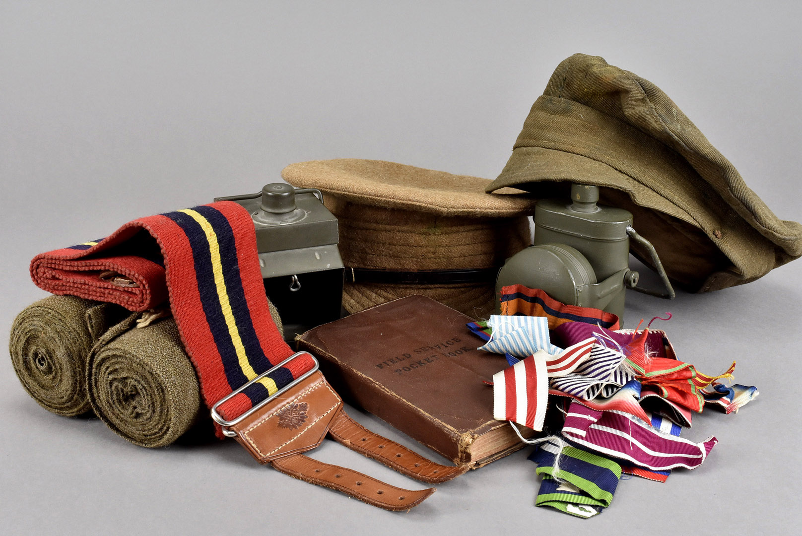 An assortment of military items, including two WWI cap, dated 1916 to inside of each, two small