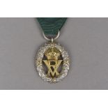 A Volunteer Officer's Decoration, with Victoria VR Royal cipher, on dark green ribbon with oak bar