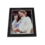 David Bowie / Autograph, A mounted 8"x10" colour photograph, signed in blue pen Bowie, sold with