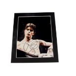 David Bowie / Autograph, A mounted 8"x10" colour photograph, signed in blue pen Bowie 94, sold