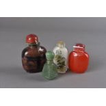 Three Chinese glass snuff bottles, one with reverse painted decoration, together with a carved