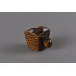 A Meiji period Japanese signed carved wood netsuke, modelled as a gong with large snail to one