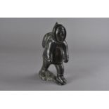 An Inuit soapstone carving, depicting an Inuit figure with back pack 23.5 cm H