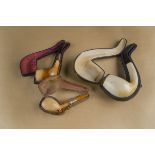 Three cased meerschaum pipes, plain bowls, two with silver collars and amber mouth pieces the