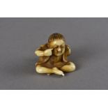 A Meiji period Japanese ivory carved netsuke, modelled as a seated boy with one hand raised