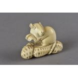 A Meiji period signed Japanese ivory netsuke, modelled as a rat surmounting peanuts, indistinctly