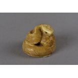 A Japanese signed ivory netsuke, modelled as a coiled snake, with metal eyes and protruding
