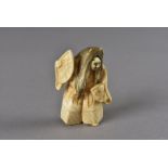 A Meiji period Japanese signed ivory netsuke, modelled as a Noh theatre dancer with two fans and