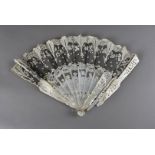 A 19th century mother of pearl and lace fan, the lace mount on a black ground, above a decorative