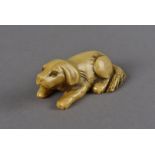 A Japanese ivory netsuke, modelled as a recumbent dog with curled tail, 5.8 cm x 2 cm