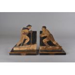 A pair of Art Deco bookends, with incise carved and dark stained sporting figures representing Rugby