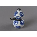 A Meiji period Japanese double gourd porcelain netsuke and snuff bottle, the blue and white mon