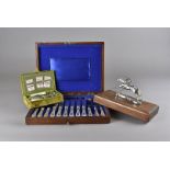 An Edwardian needlecase and manicure set, in fitted green velvet case, a silver plated canteen of